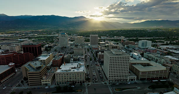 Aerial shot of Colorado Springs, Colorado on a summer evening after a rainstorm, as the sun sets behind Pikes Peak and the Front Range of the Rocky Mountains.