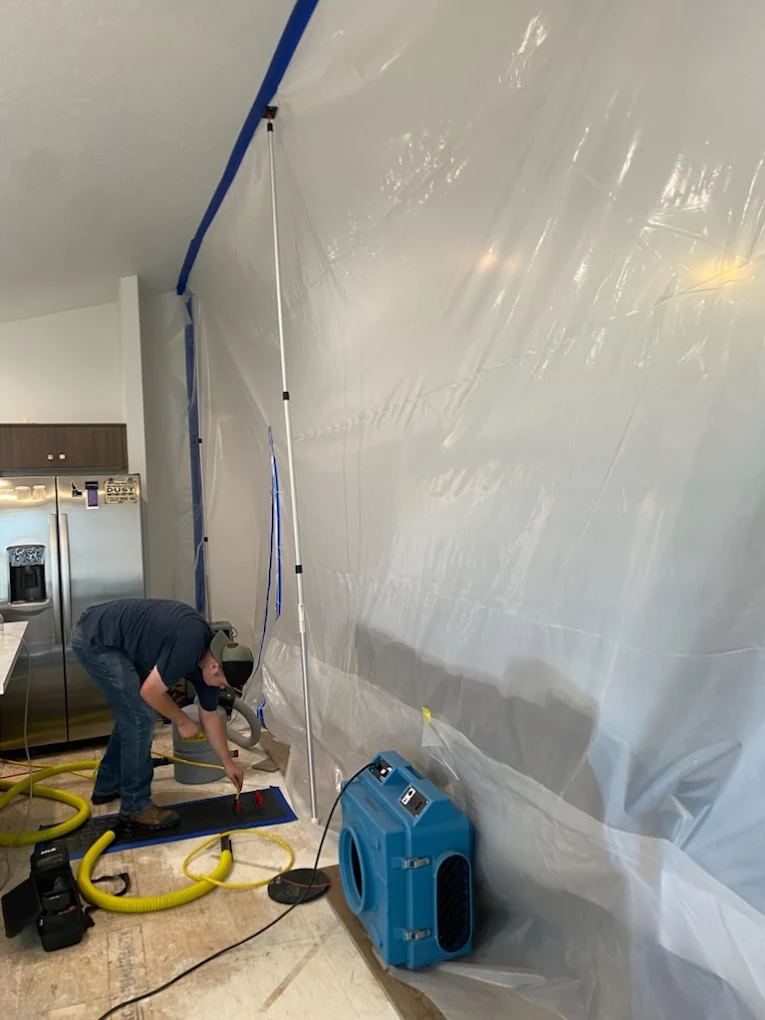 RestoPros wroker putting up a tarp