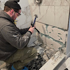 Joliet Restopros team member working on a job with a hammer.