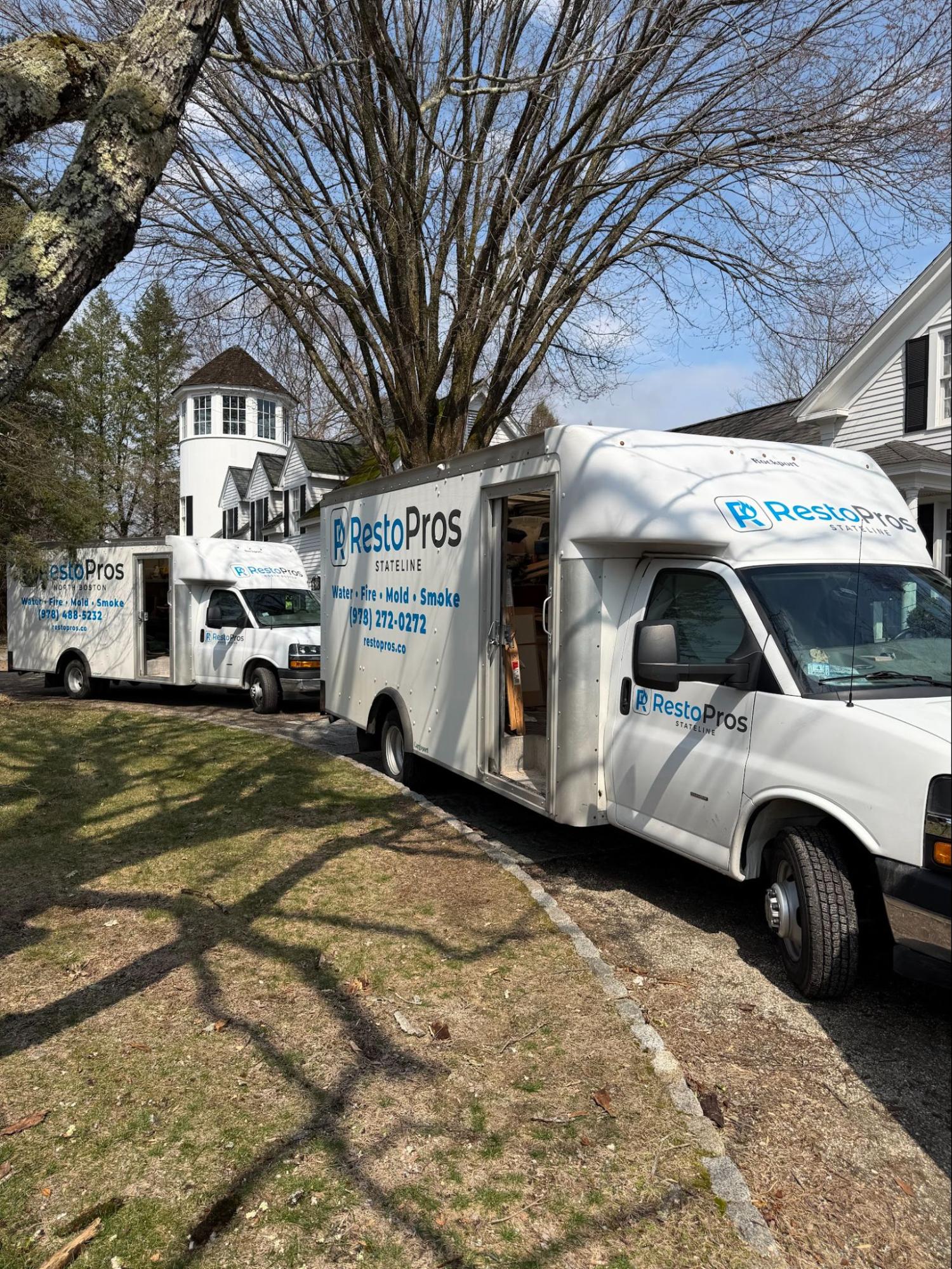 restopros trucks on curb of home