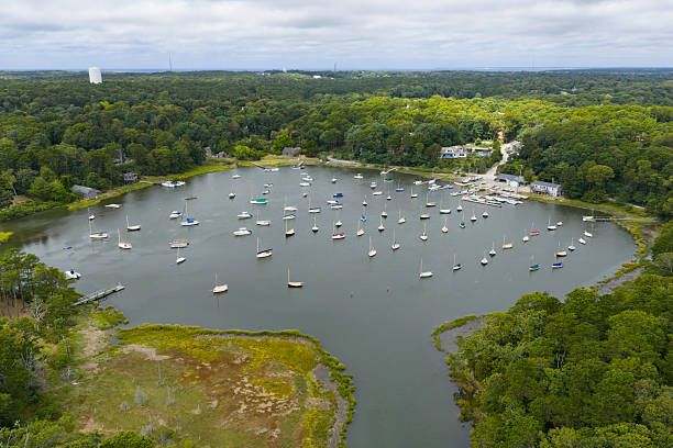 A bird's eye view shows a variety of small boats moored in Arey's Pond in Orleans, MA.