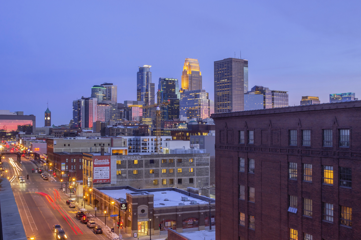 A Wide Angle Shot of Downtown Minneapolis Reflecting Pink Dusk Light as North Loop Traffic Passes in the Foreground