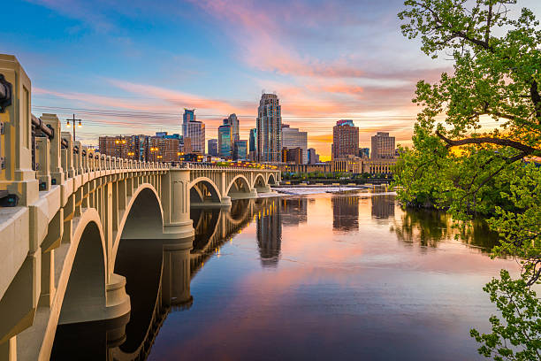 Minneapolis, Minnesota, USA downtown skyline on the Mississippi River with the Third Avenue Bridge at twilight.
