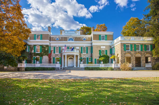 The Home of Franklin D. Roosevelt, 32nd President of the United States, is a National Historic Site. This site preserves the Springwood estate which is located in Hyde Park, New York. The Springwood was the birthplace, home, and burial place of the FDR (Franklin Delano Roosevelt). Vivid blue sky with clouds, grass and trees in fall colors are in the image. HDR (high dynamic range) image, Canon EOS 6D (full frame sensor).