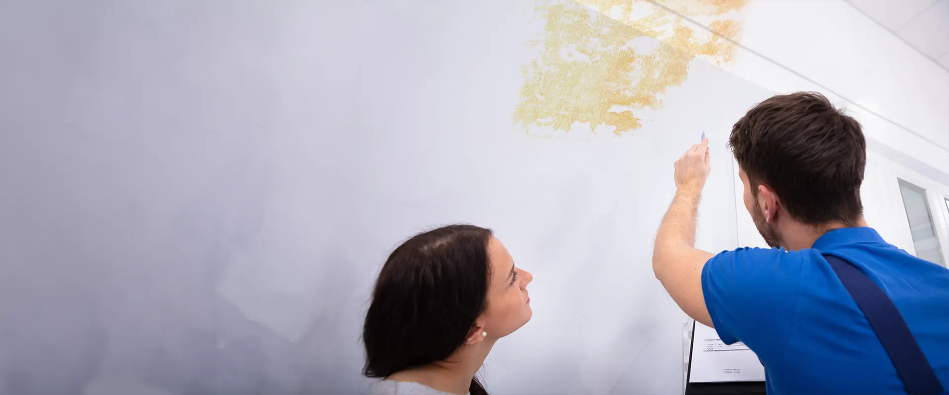 repair person showing woman water damage