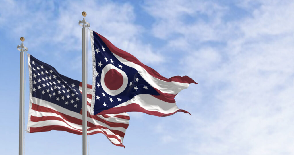 Ohio state flag waving in the wind with the national US flag on a clear day. 3D illustration render. Rippled textile. Selective focus
