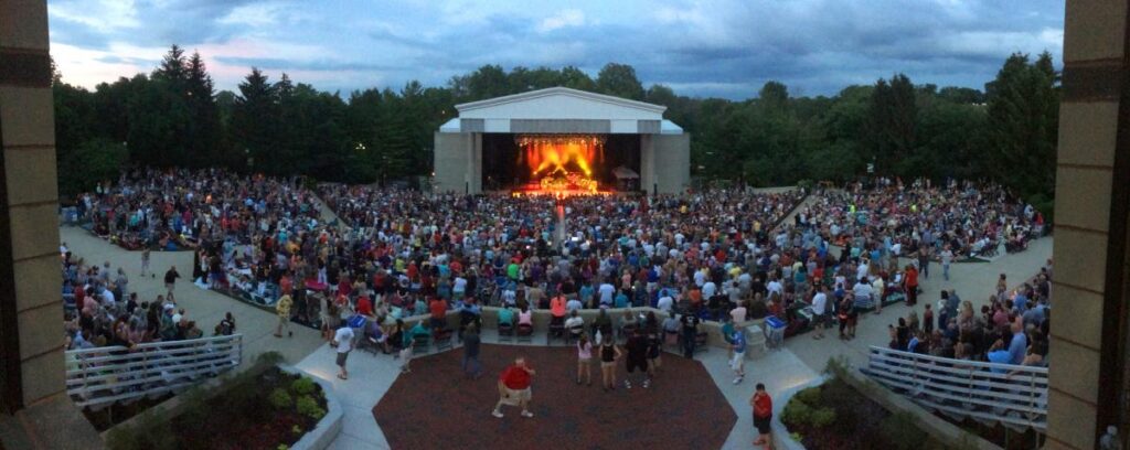 Large crowd attending an outdoor concert at a Kettering amphitheater