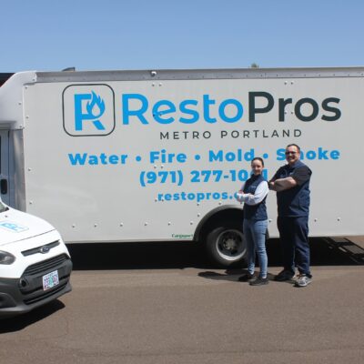 Team members standing in front of a RestoPros truck