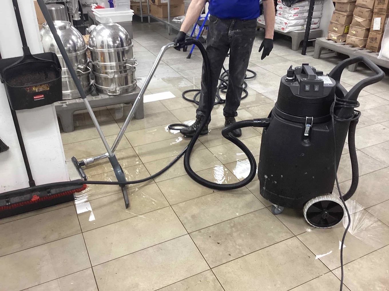 flooded tile floor being vaccuumed