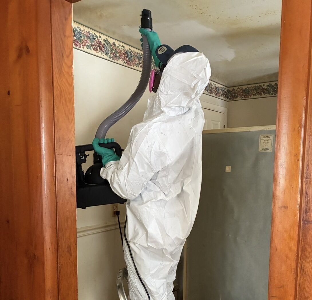 Restopros team member working to repair water damage in a New London home.