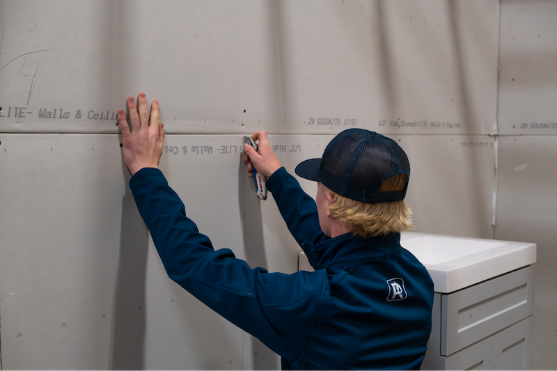 Man working on wall for water damage restoration