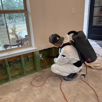 Worker kneeling on floor in a hazmat suit