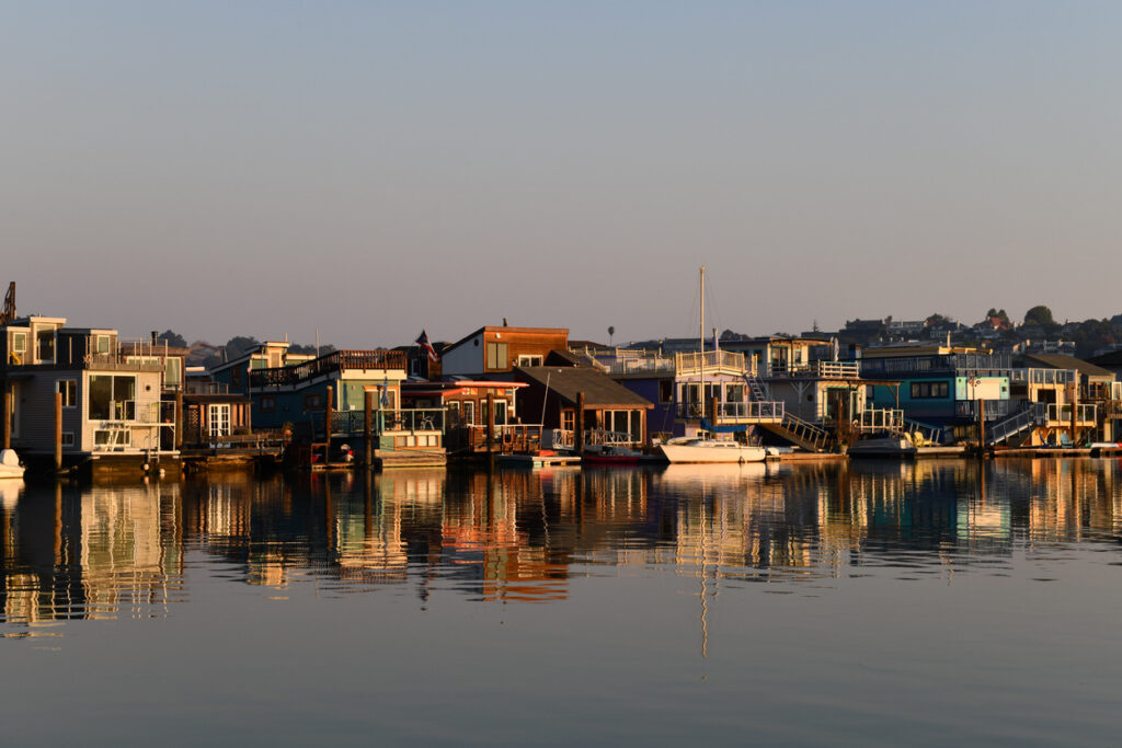 Colorful wooden house boats reflected into the still water