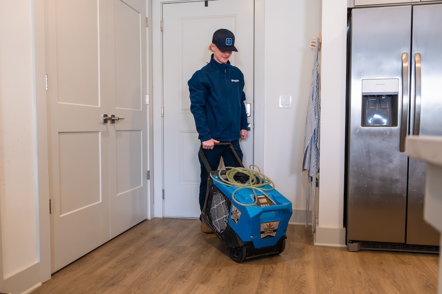 A woman rolling a fan to fix water damage