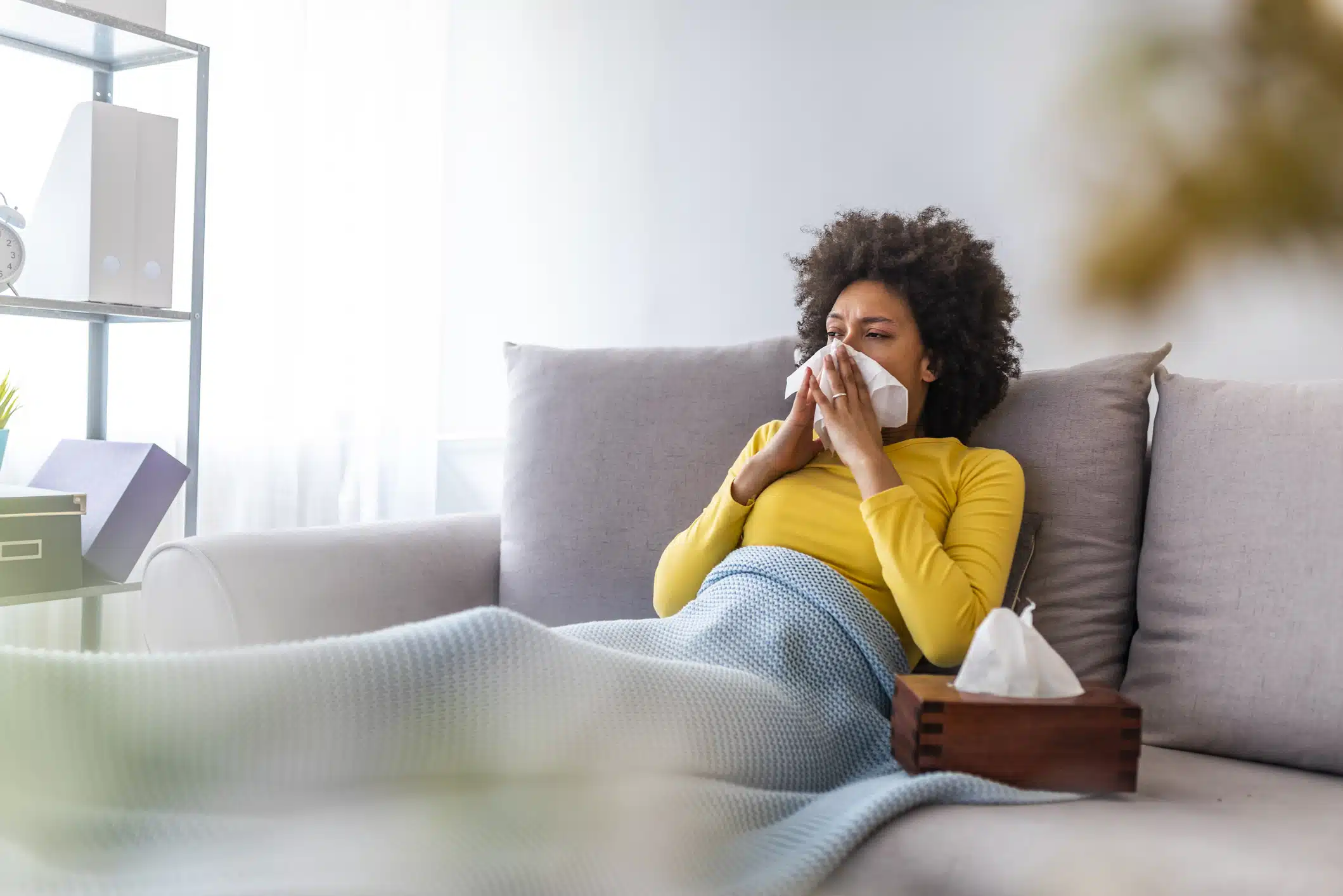 Picture showing sick woman sneezing at home