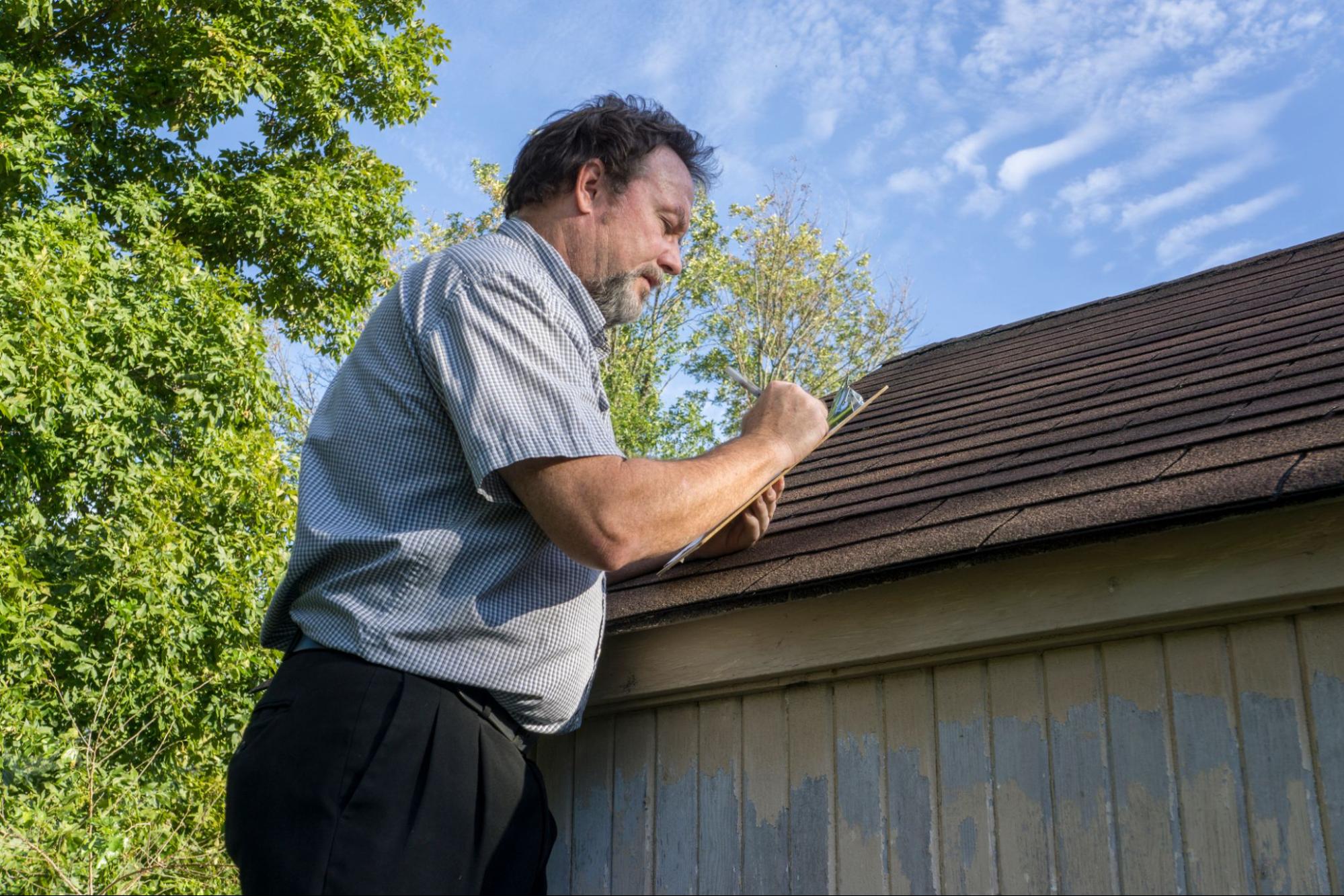 man inspecting roof
