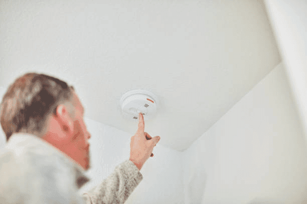 image of a man adjusting the smoke detector