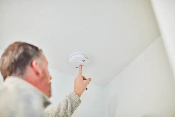 image of a man adjusting the smoke detector