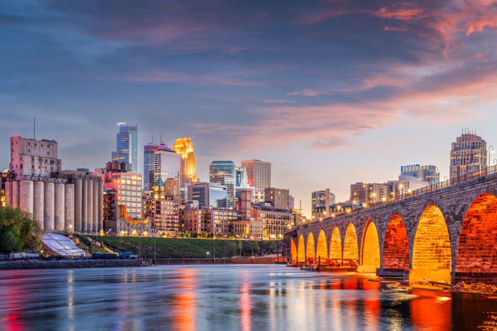 Minneapolis, Minnesota, USA skyline with the Stone Arch Bridge on the Mississippi River at dusk.