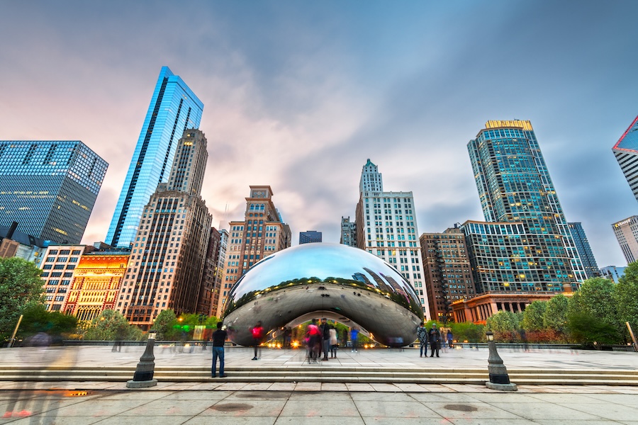 An image of the bean and surrounding city at sunset